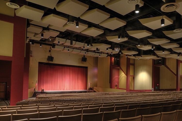 Empty theatre with closed red curtains